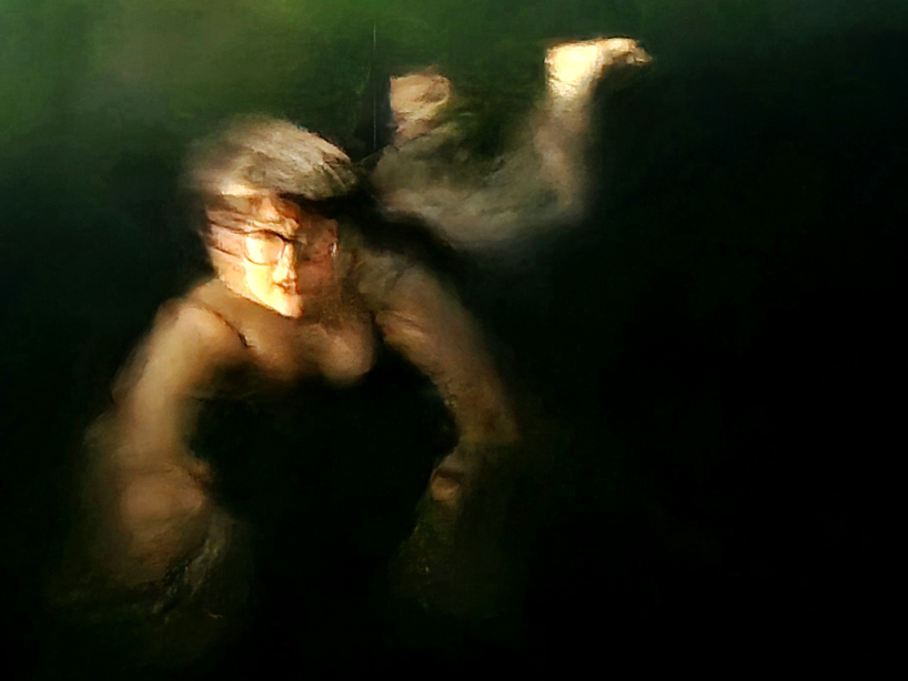 Figure lit in warm light against near-black water, Goya-like tonal contrast from handheld camera movement